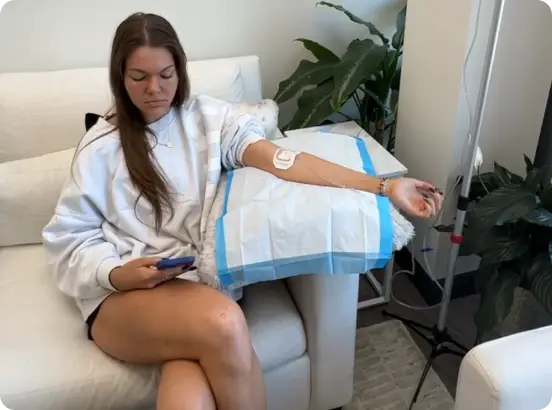 A client resting in the Hydrate GA lounge while receiving 100% bioavailable IV nutrients to address fatigue and brain fog.